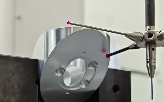 Coordinate measuring machine probing a machined aluminium part on a granite table